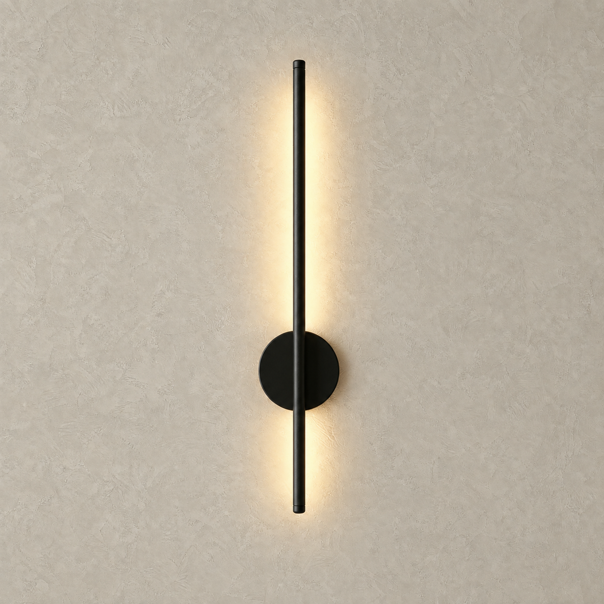 Nedrila black LED wall sconce lit and casting warm light across a plaster wall