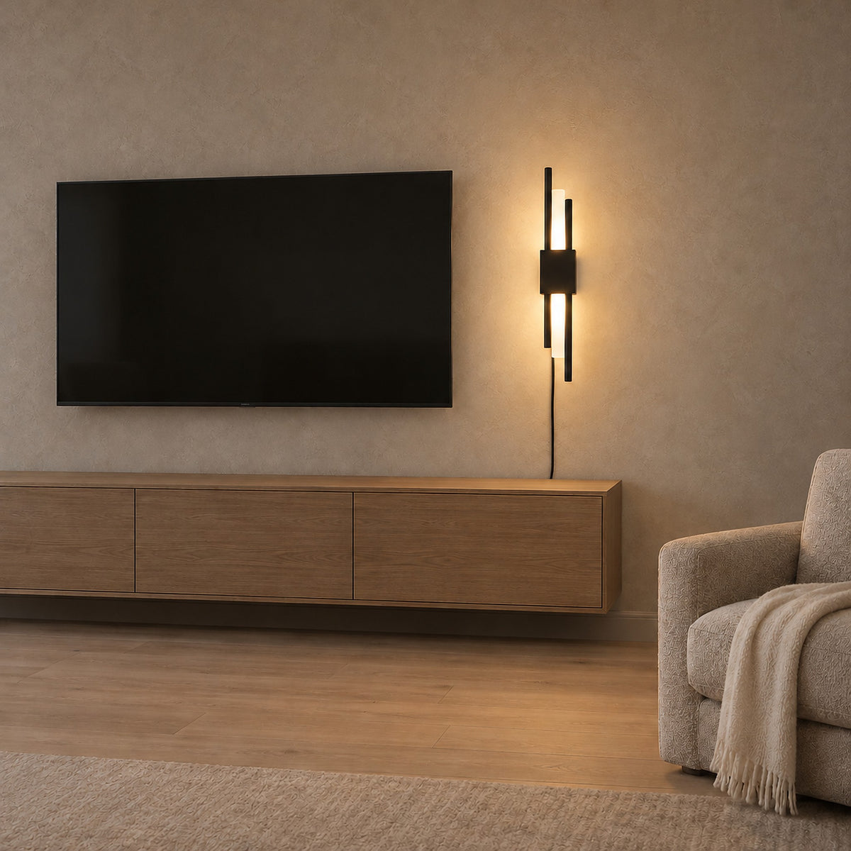 Nemirsa black wall sconce lit above an empty console beside den seating