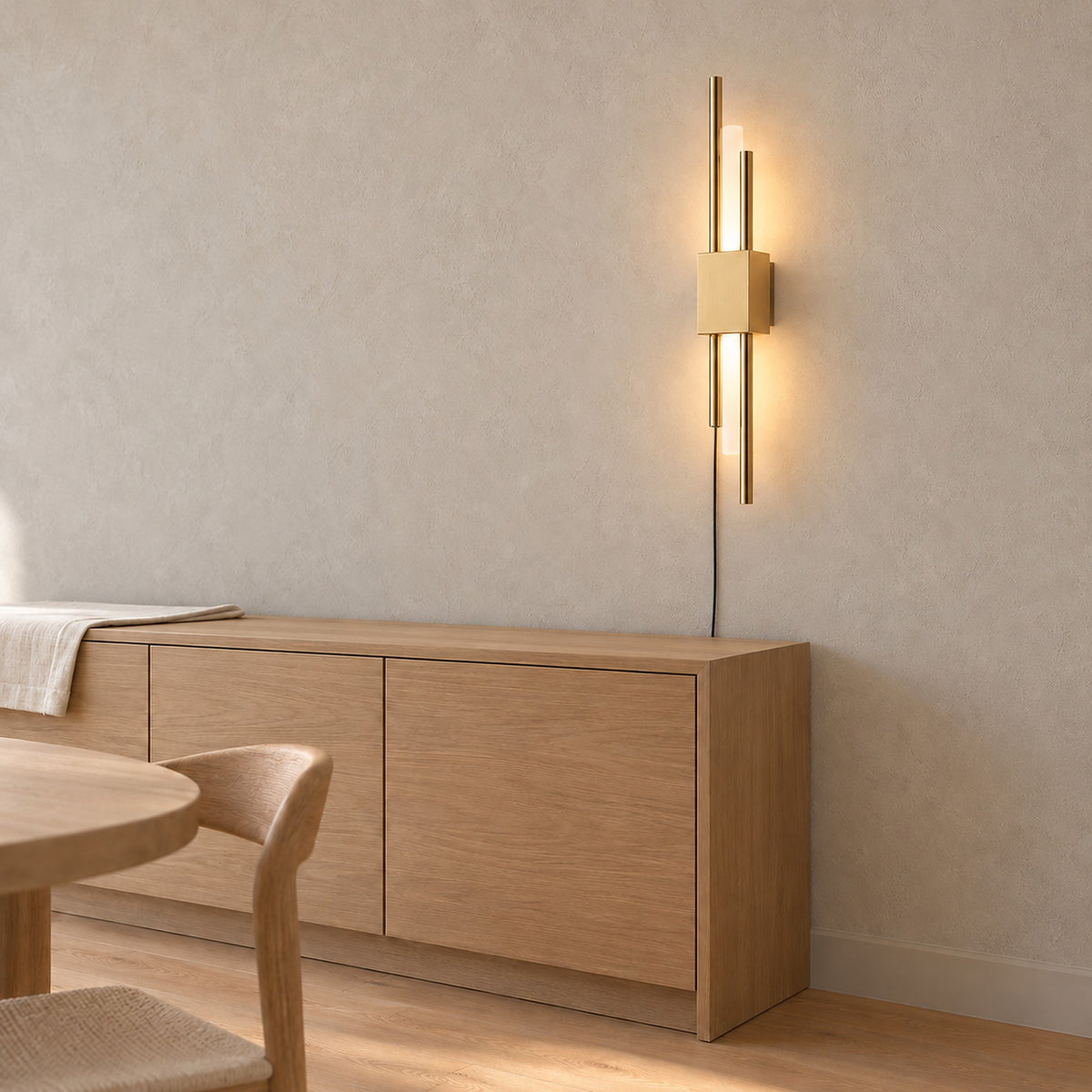Nemirsa gold wall light switched on above pale furniture in a daylit dining room #color_gold