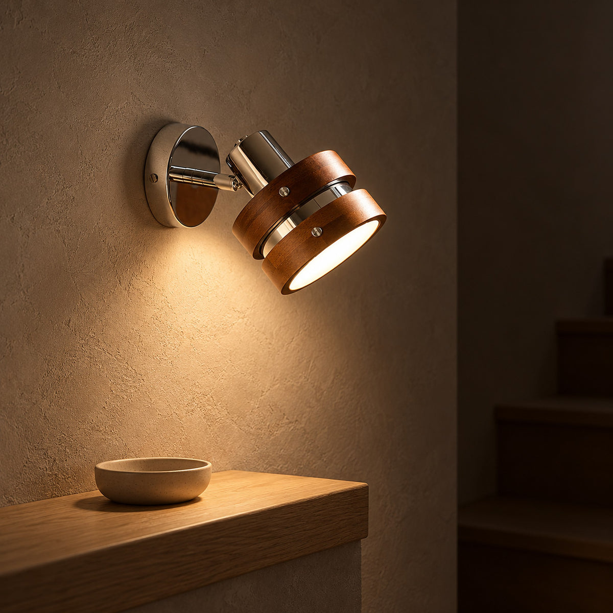 Nerilvo chrome and walnut wall lamp giving warm light on a stair landing wall at night