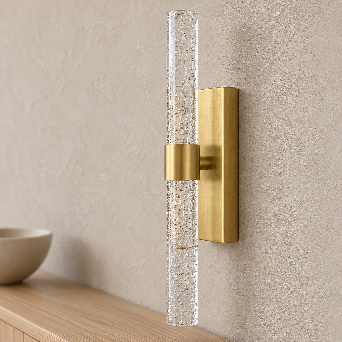 Nimarlo gold wall sconce close up of the clear acrylic rod and gold finish in a daylit dining room
