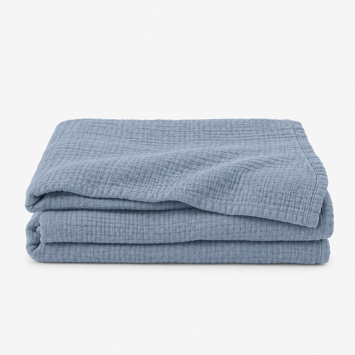 Nolavira blue cotton throw blanket loosely folded on white, showing its naturally crinkled cotton
