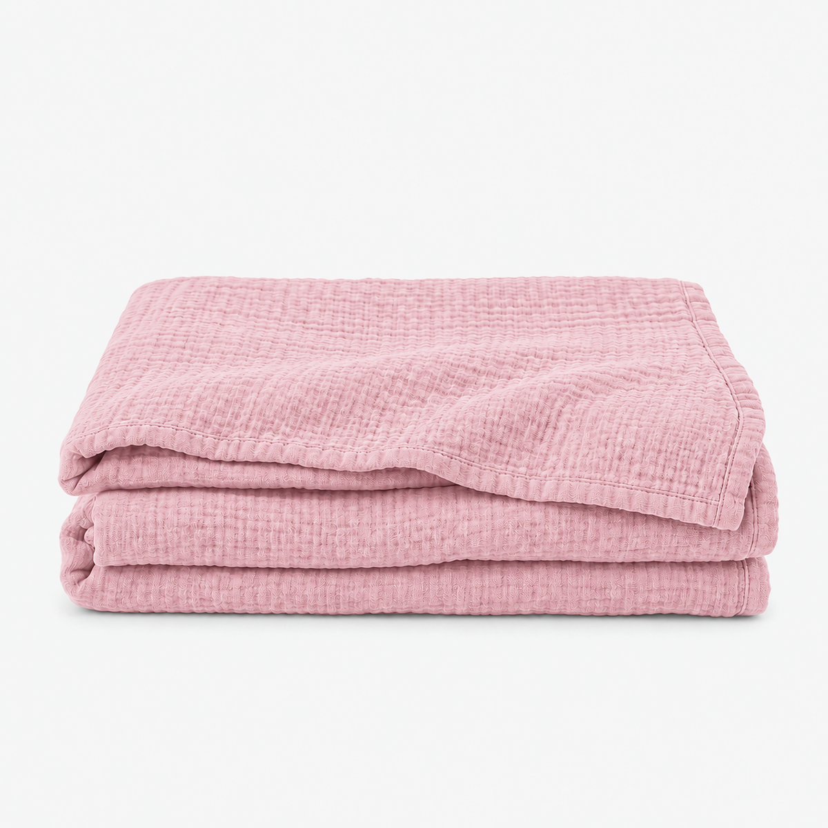 Nolavira pink cotton throw blanket loosely folded on white with its natural wrinkled texture #color_pink