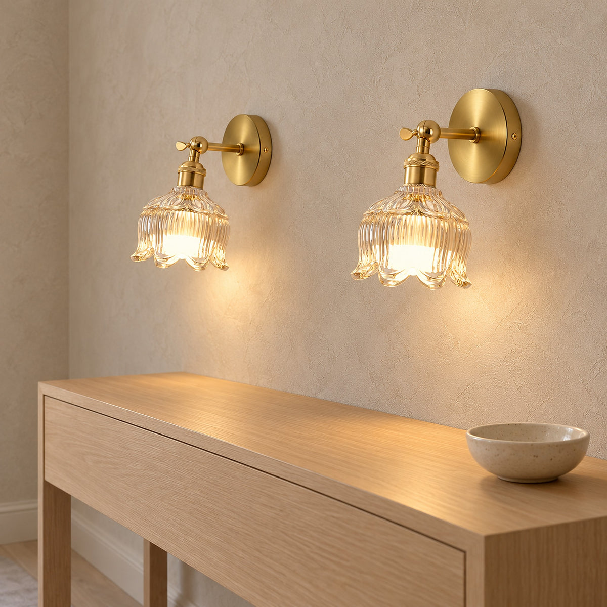Pair of Nolavire golden battery operated wall sconces in close view with plated metal fitting and lit glass shade