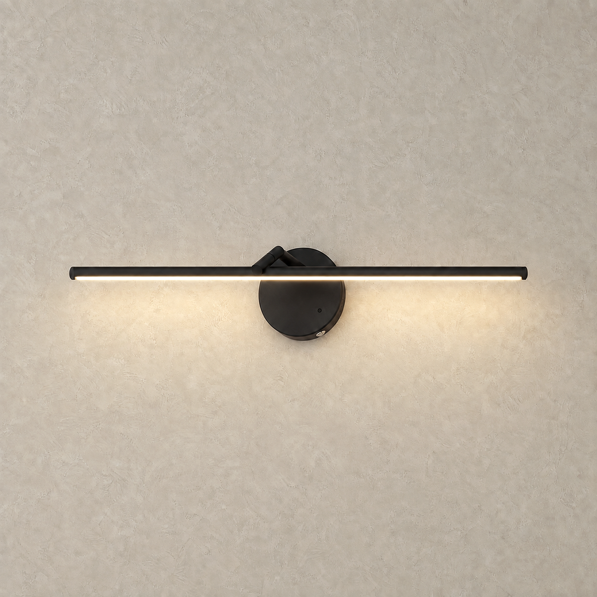 Nolesira black LED wall sconce glowing warm against a greige plaster wall #color_black