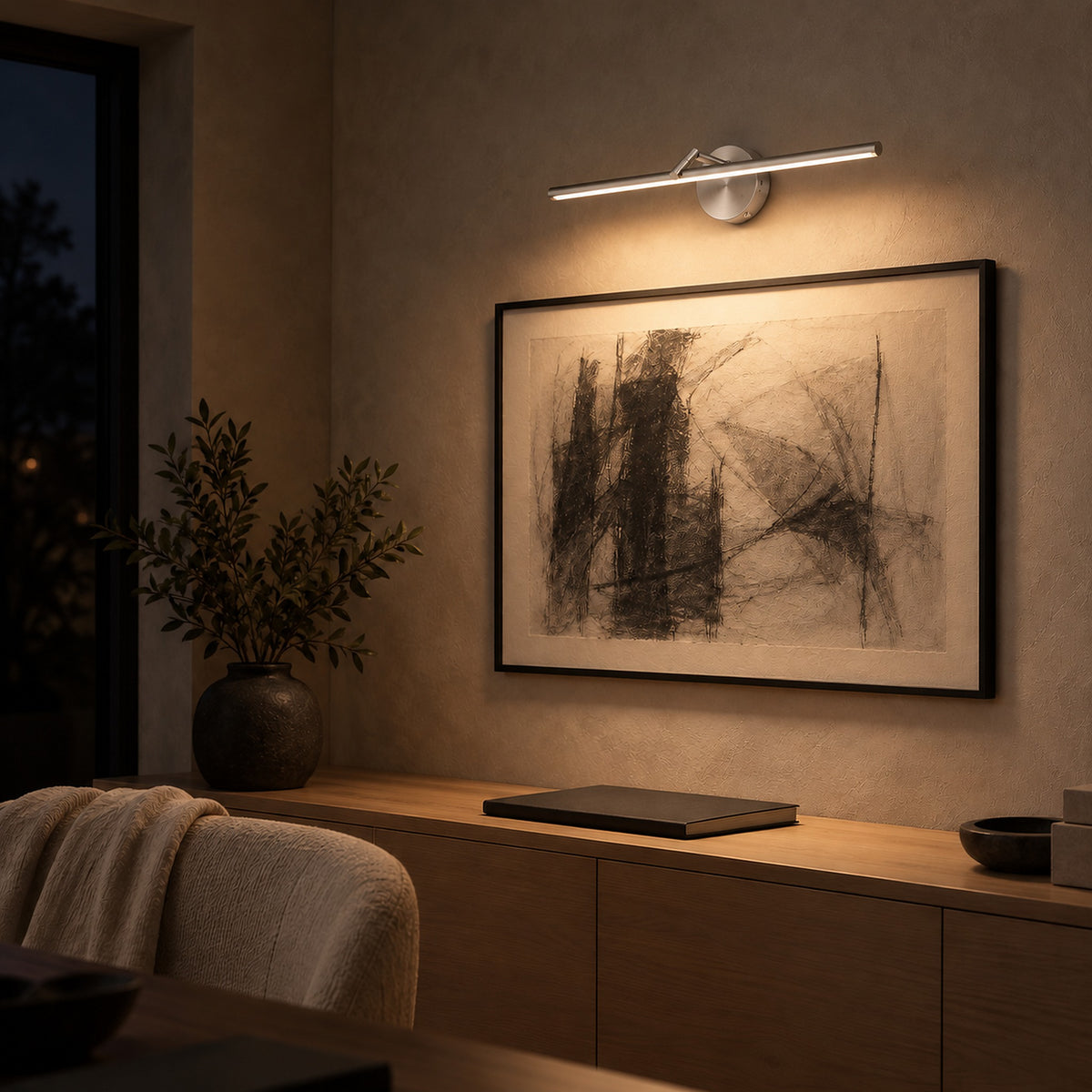 Nolesira nickel cordless wall lamp washing framed artwork in a study at night #color_nickel