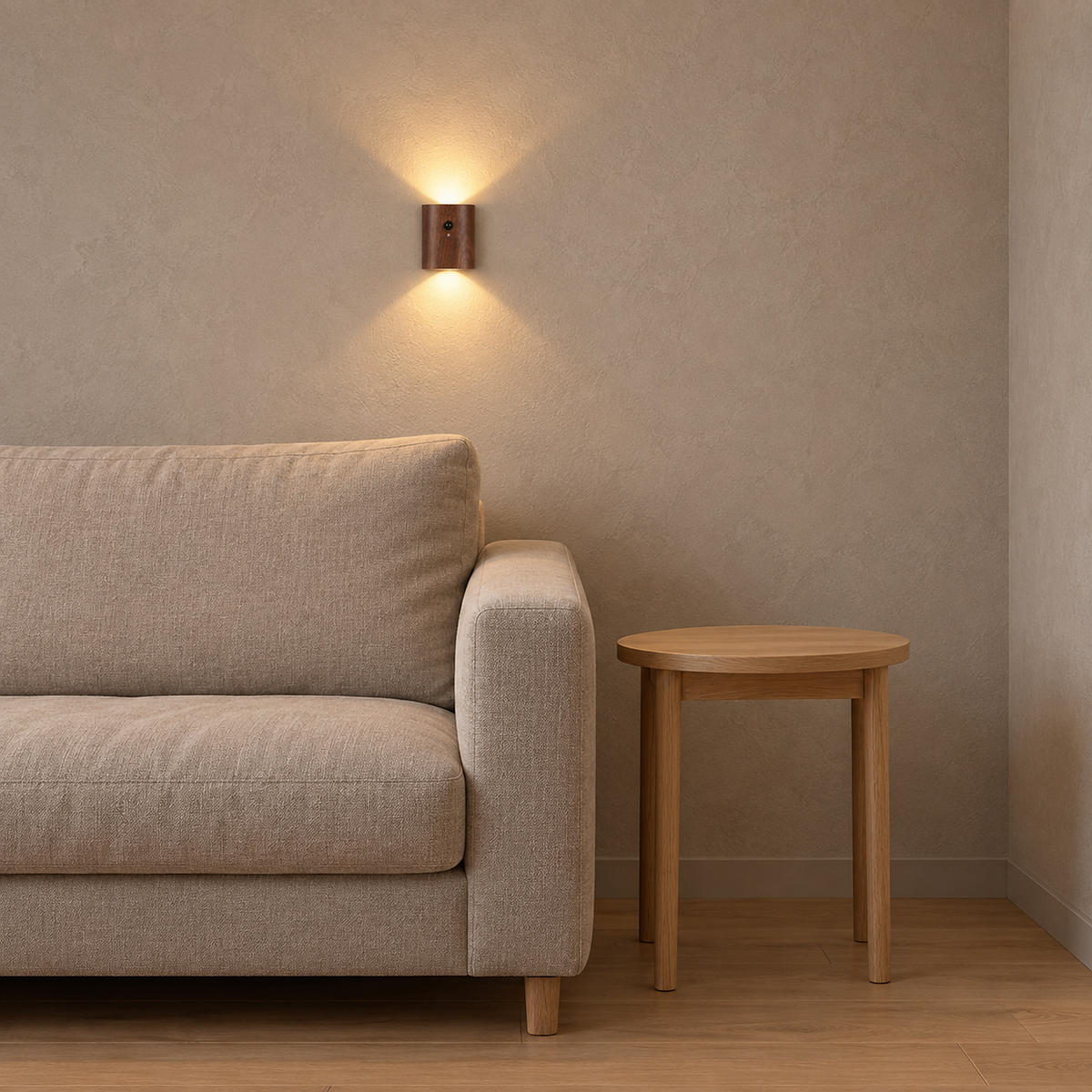 Orimane dark wood wireless wall light glowing above an oatmeal sofa beside a bare table