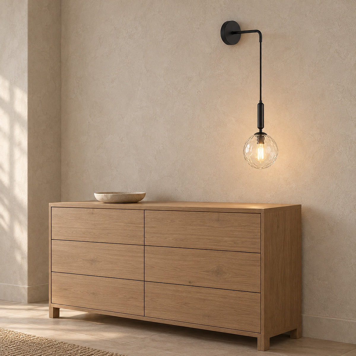 Orlamen black wall light switched on in a dressing alcove, the bulb glowing through clear glass