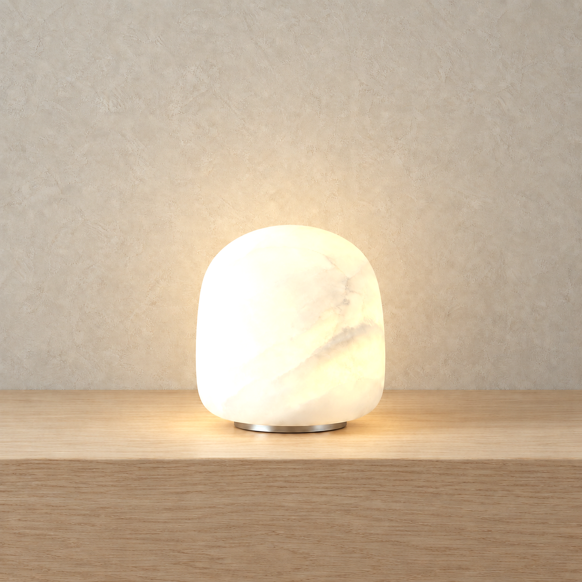 Ravelmo white portable table lamp lit up so the cloudy veining of its body shows through the glow