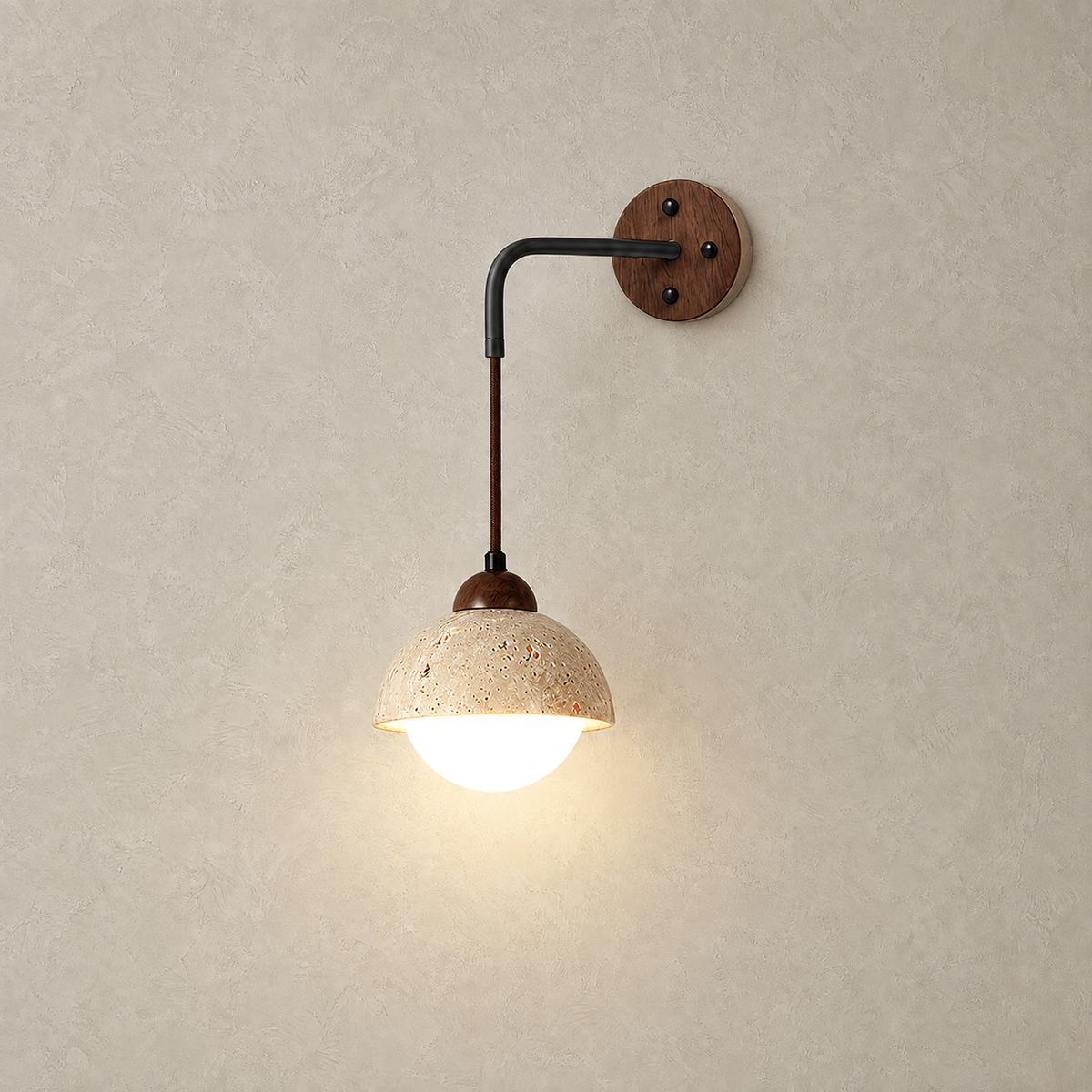 Relmino model B walnut bedside lamp lit on a plain plate showing the wood body and stone shade