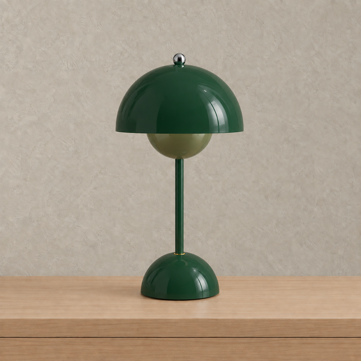 Retomira green table lamp shown unlit against a plain plaster wall #color_green
