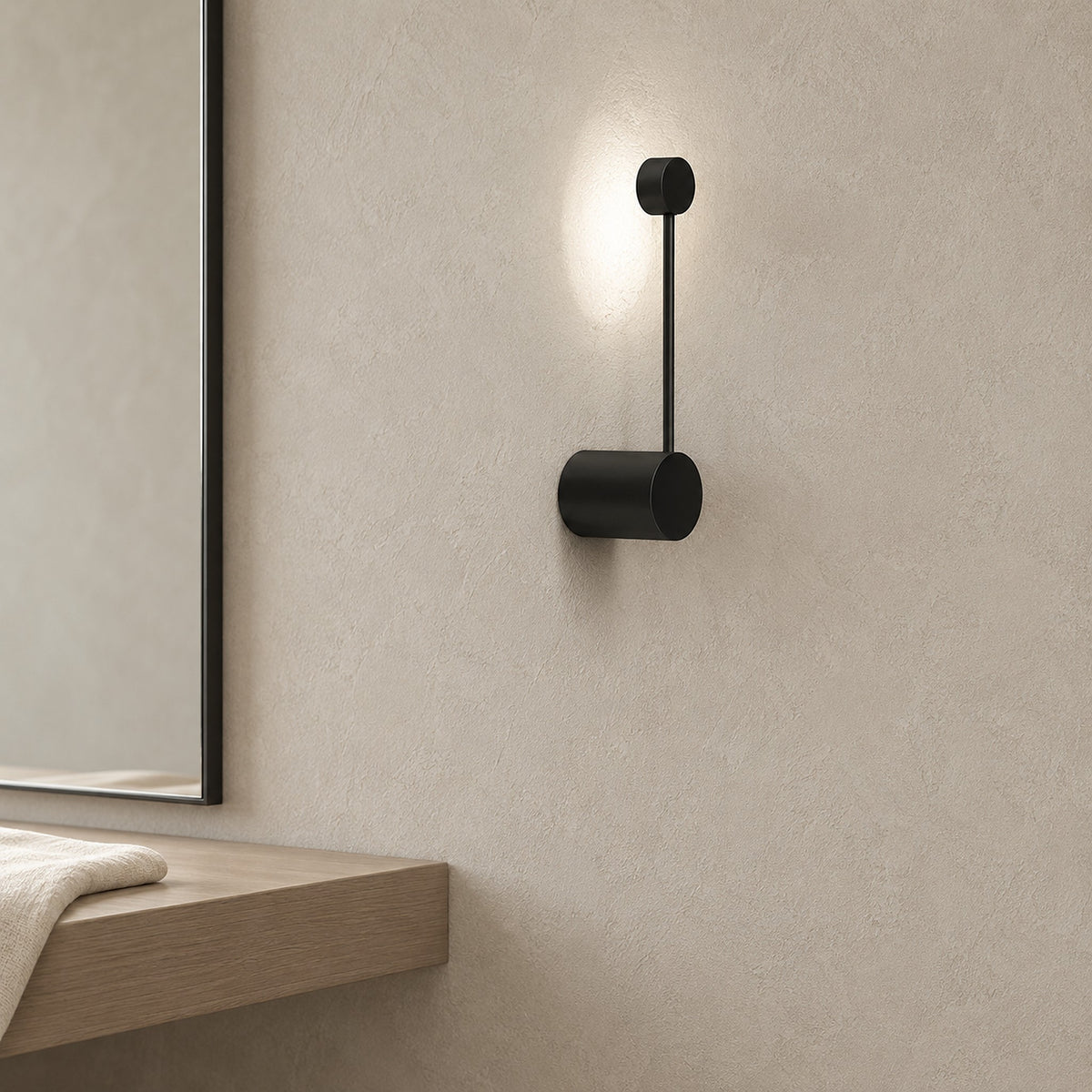 Rilameo black hardwired wall light with clean wall mounting, lit in a dressing room