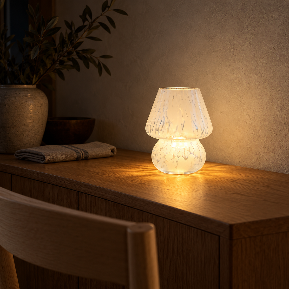 Rimelota white table lamp on a warm setting casting pools of light across a dining table at night #color_white