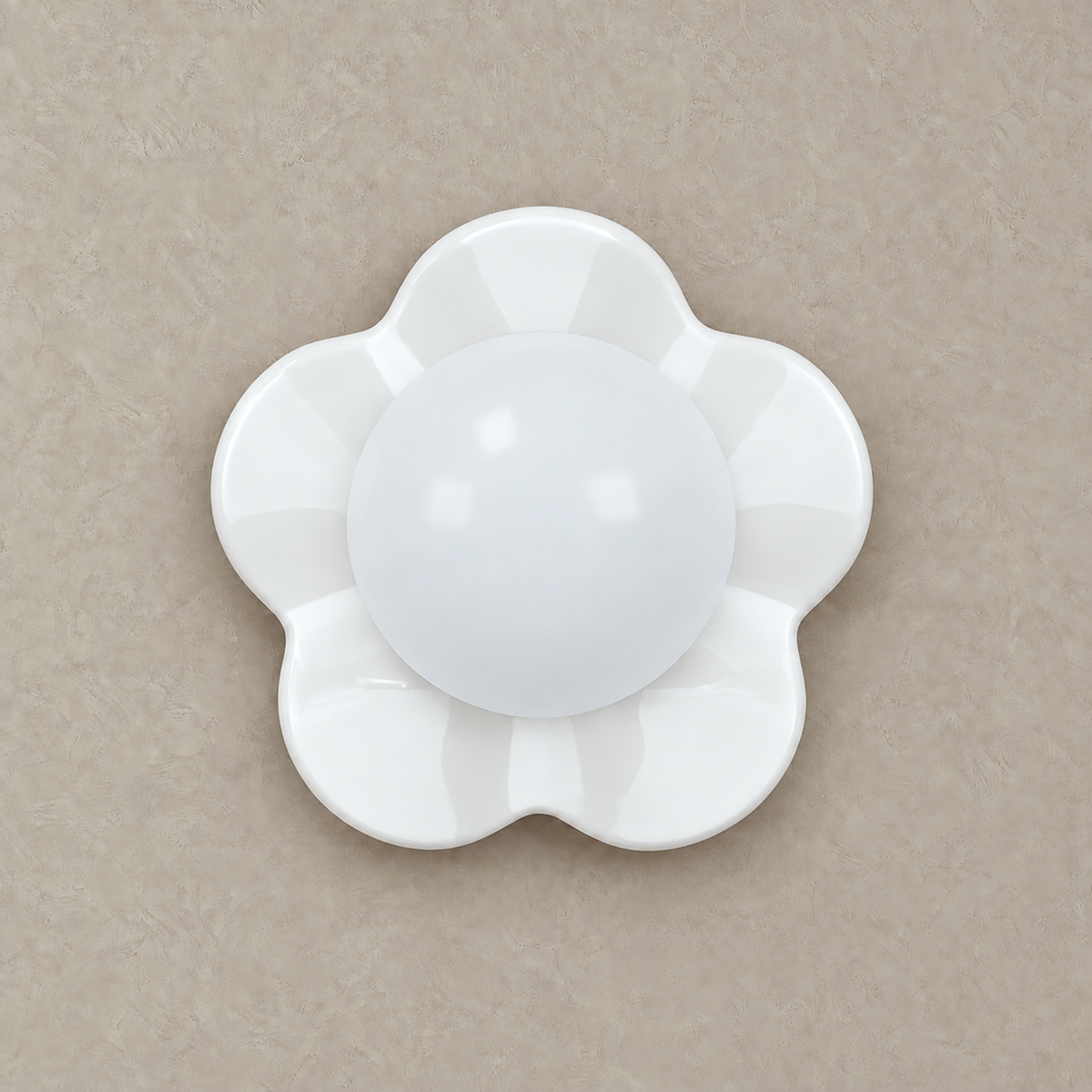 Rovilan white flower wall sconce with its glass globe unlit on a plain studio plate