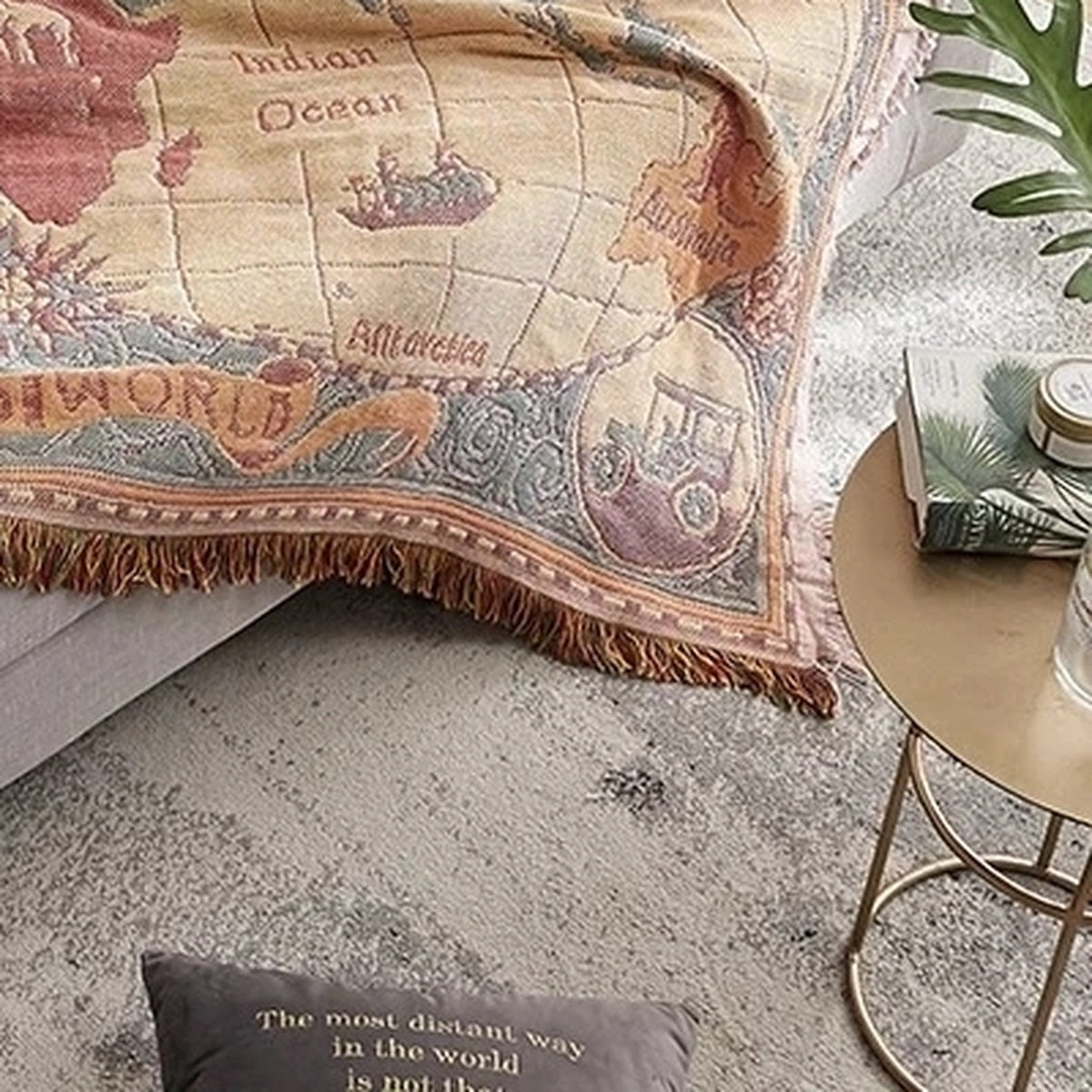 Saloveri world map throw blanket draped over a sofa, showing the Indian Ocean, Australia and fringed edge.