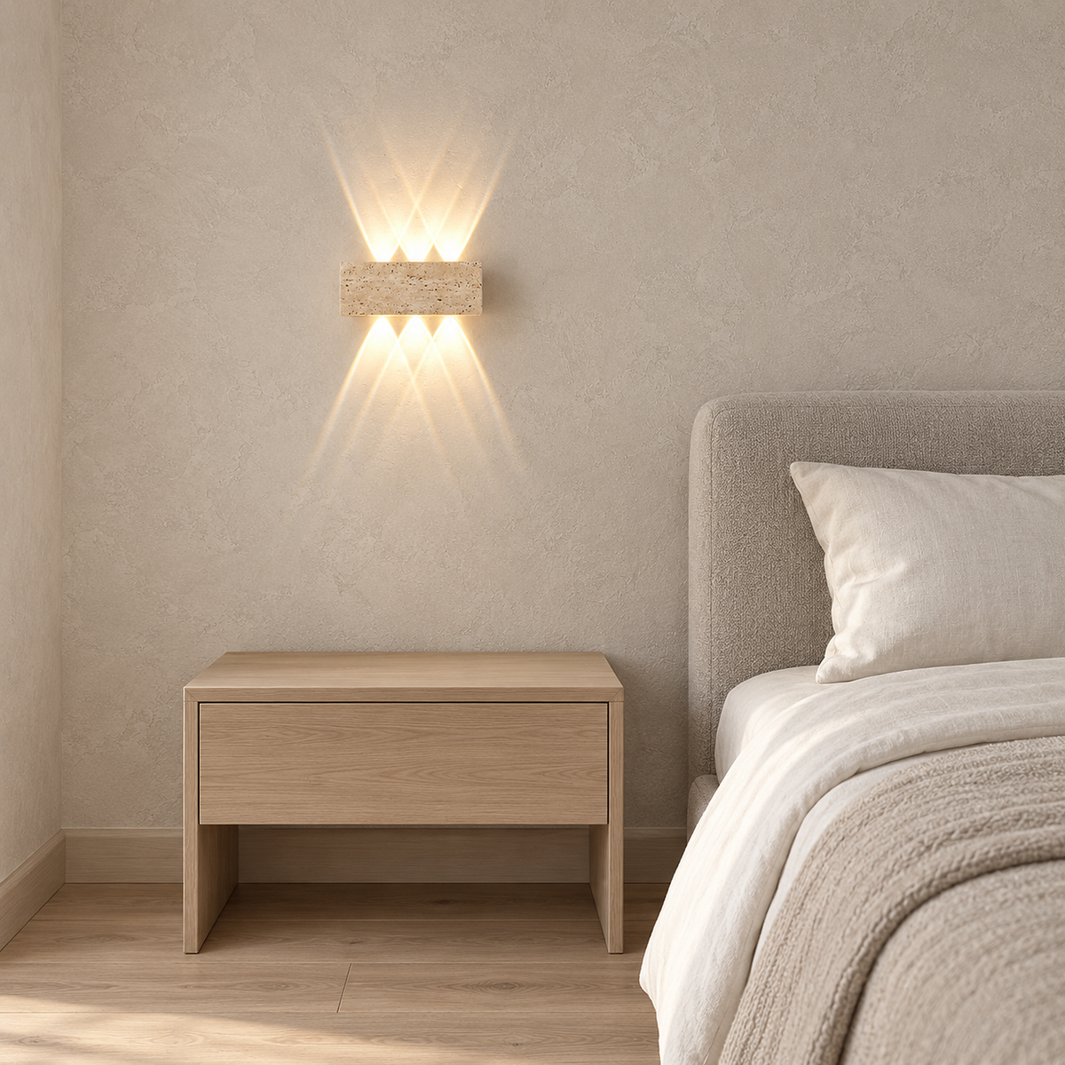 Sarivol beige stone bedside wall light, a hardwired fixture glowing warm beside a made bed in daylight