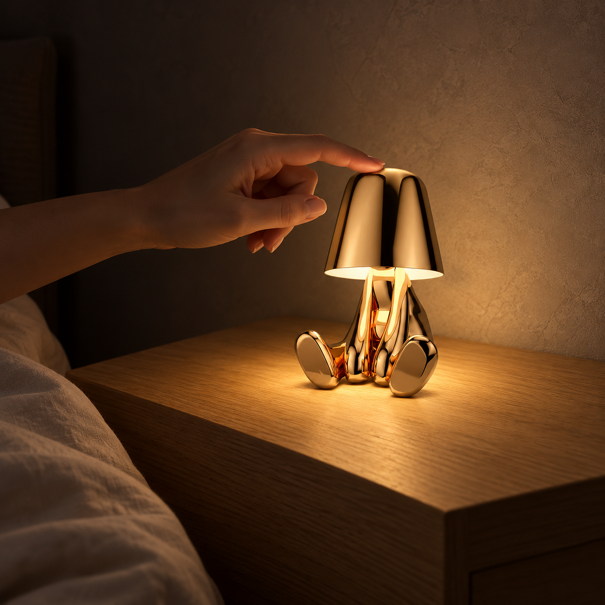 Sarovel gold battery operated table lamp casting a gentle pool of light in a bedroom at night