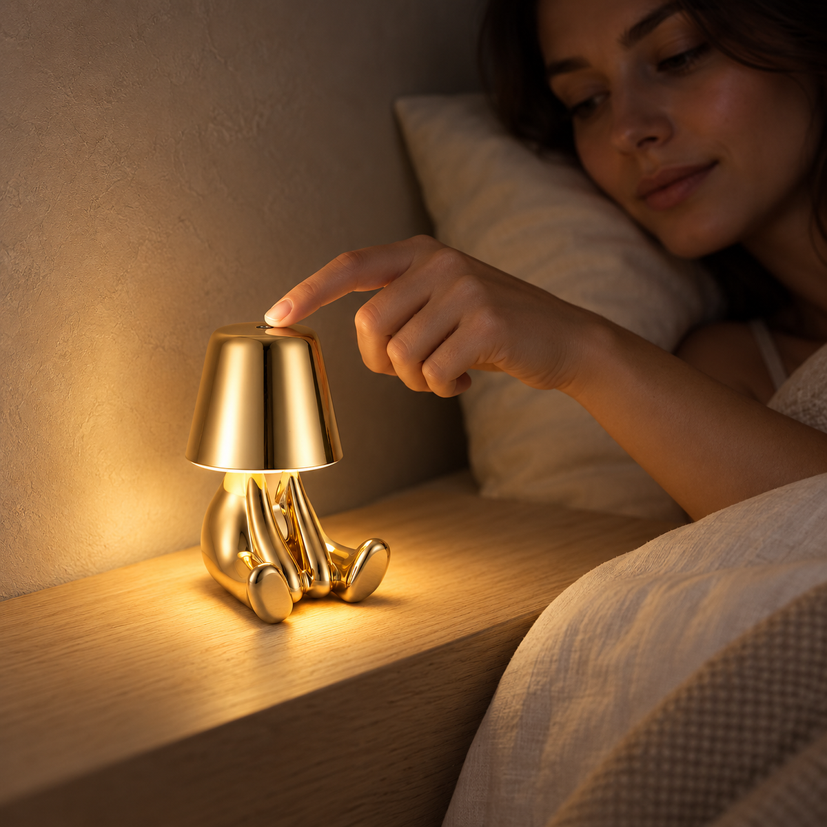 Sarovel gold bedside lamp switched on with a touch at bedtime in a guest sleeping alcove