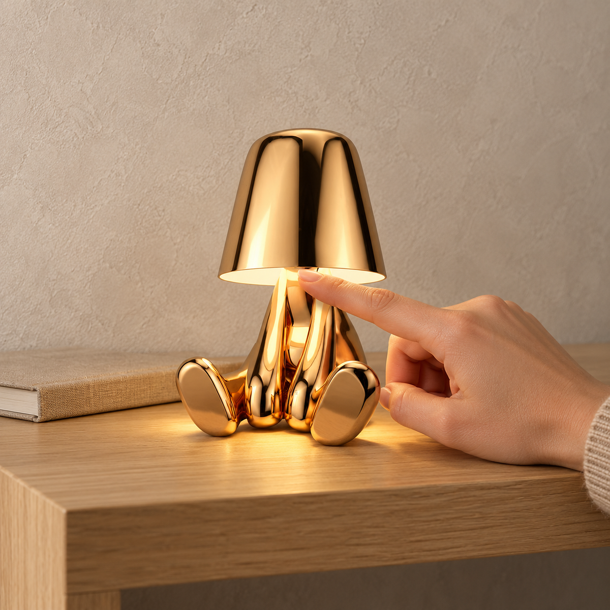 Sarovel gold table lamp switched on in an entryway, lighting its seated figure from beneath the shade