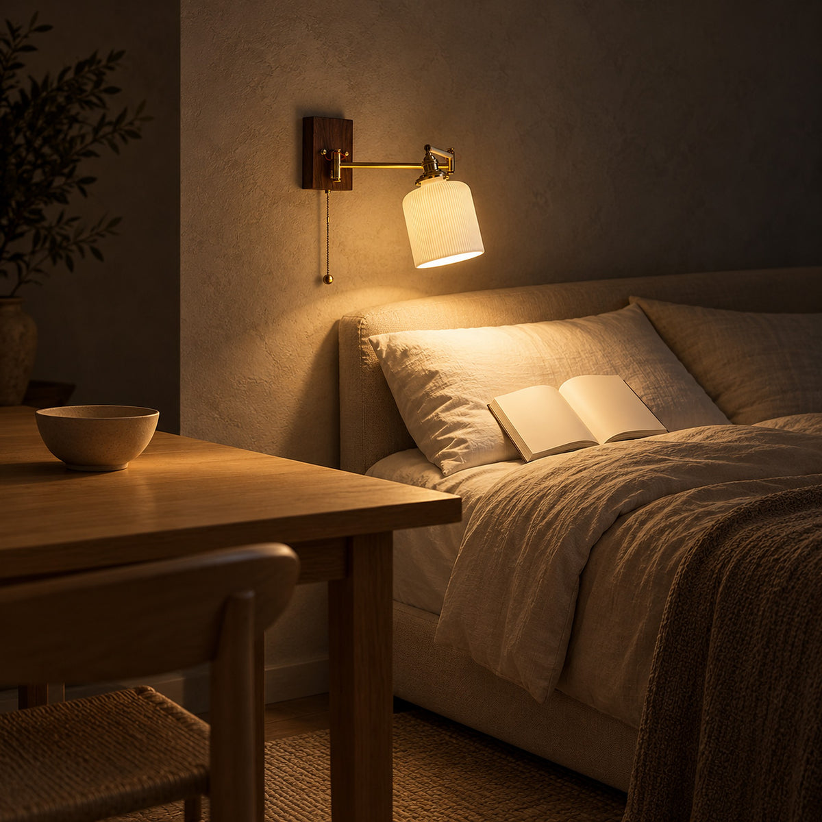 Selanvo gold and white plug in wall lamp with a tilted ribbed shade above a bed with an open book