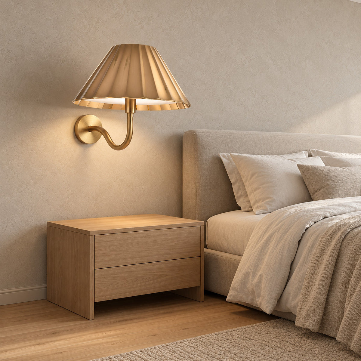 Selorna gold bedside wall light mounted above a clear bedroom nightstand