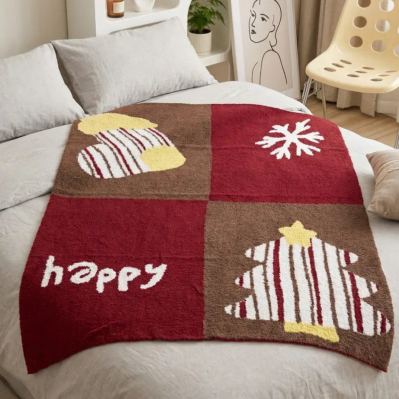 Senalio christmas fleece throw blanket spread on a bed, showing red and brown panels with a tree, snowflake and happy text