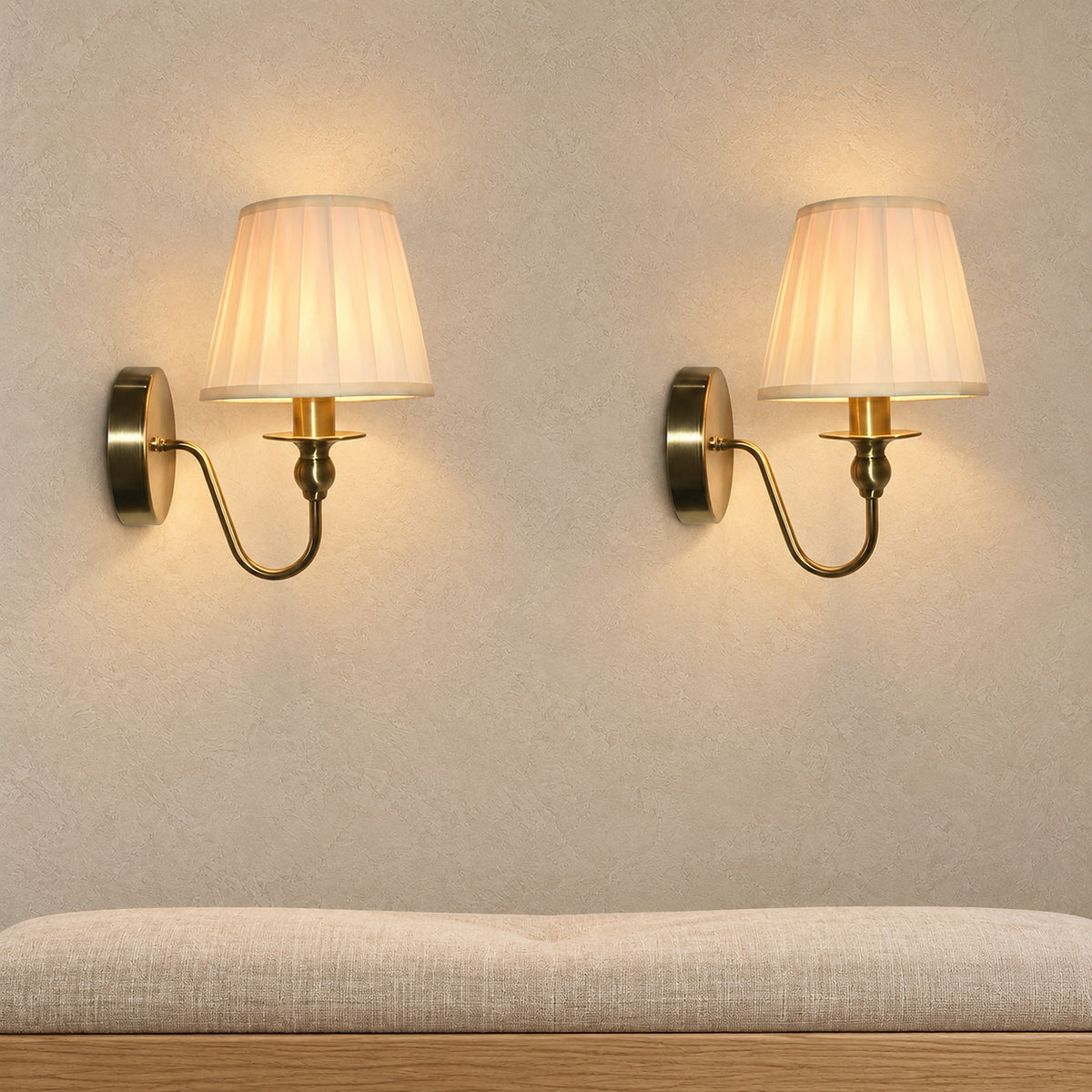 Siralto gold wall lamp pair lit above an entry bench in a bright vestibule