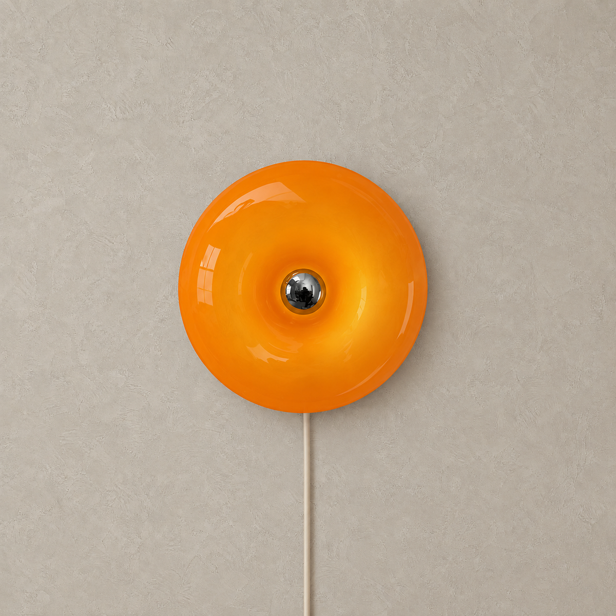 Siravel orange plug in wall lamp shown unlit, its frosted glass shade set against greige plaster