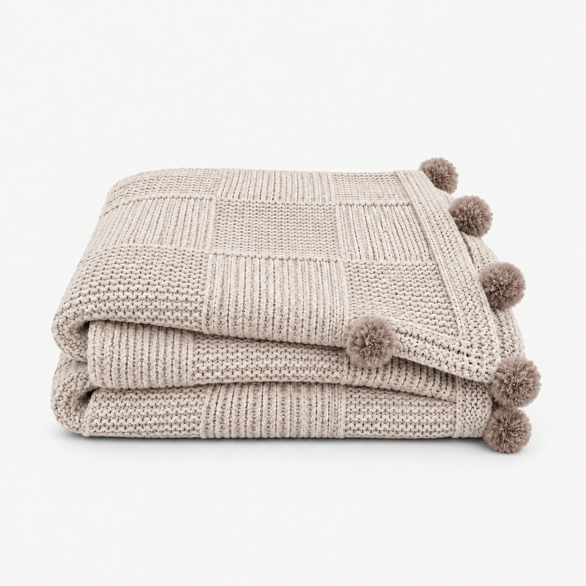 Talenvo knit throw blanket in beige, folded with fuzzy pom poms along the edges #color_beige