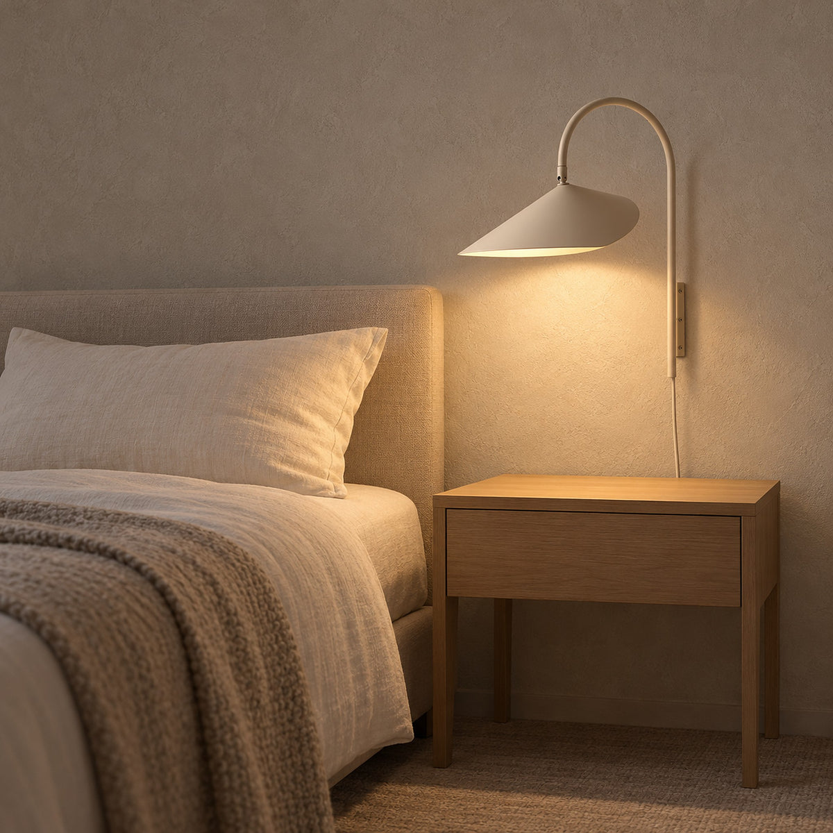 Talirsa beige bedside wall light illuminating an empty nightstand in a guest sleeping alcove #color_beige