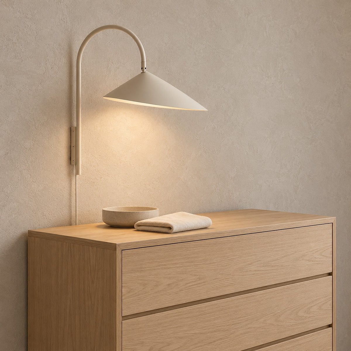 Talirsa beige wall lamp lit above a dressing chest in a bright dressing room #color_beige