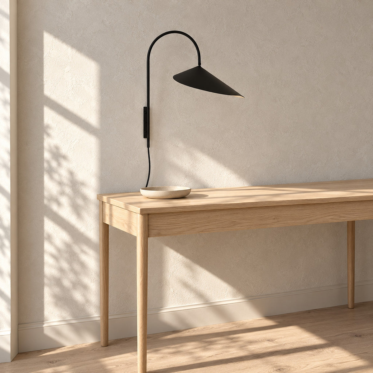 Talirsa black plug in wall light, unlit, above a console table in an entry nook