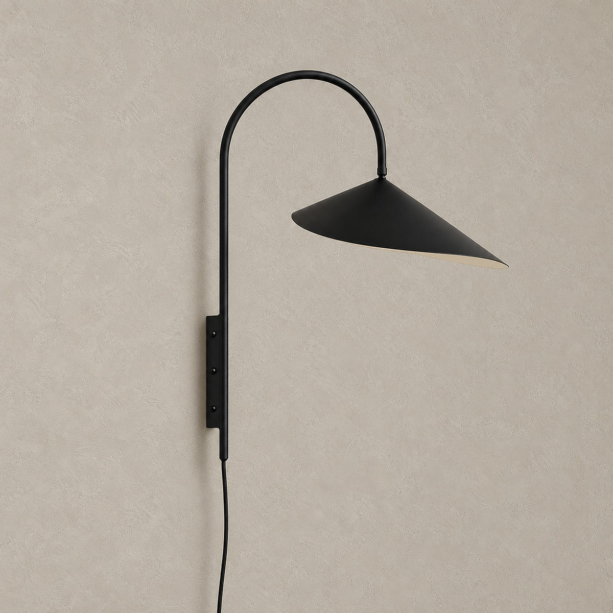 Talirsa black plug in wall sconce, unlit, mounted against a plain plaster wall