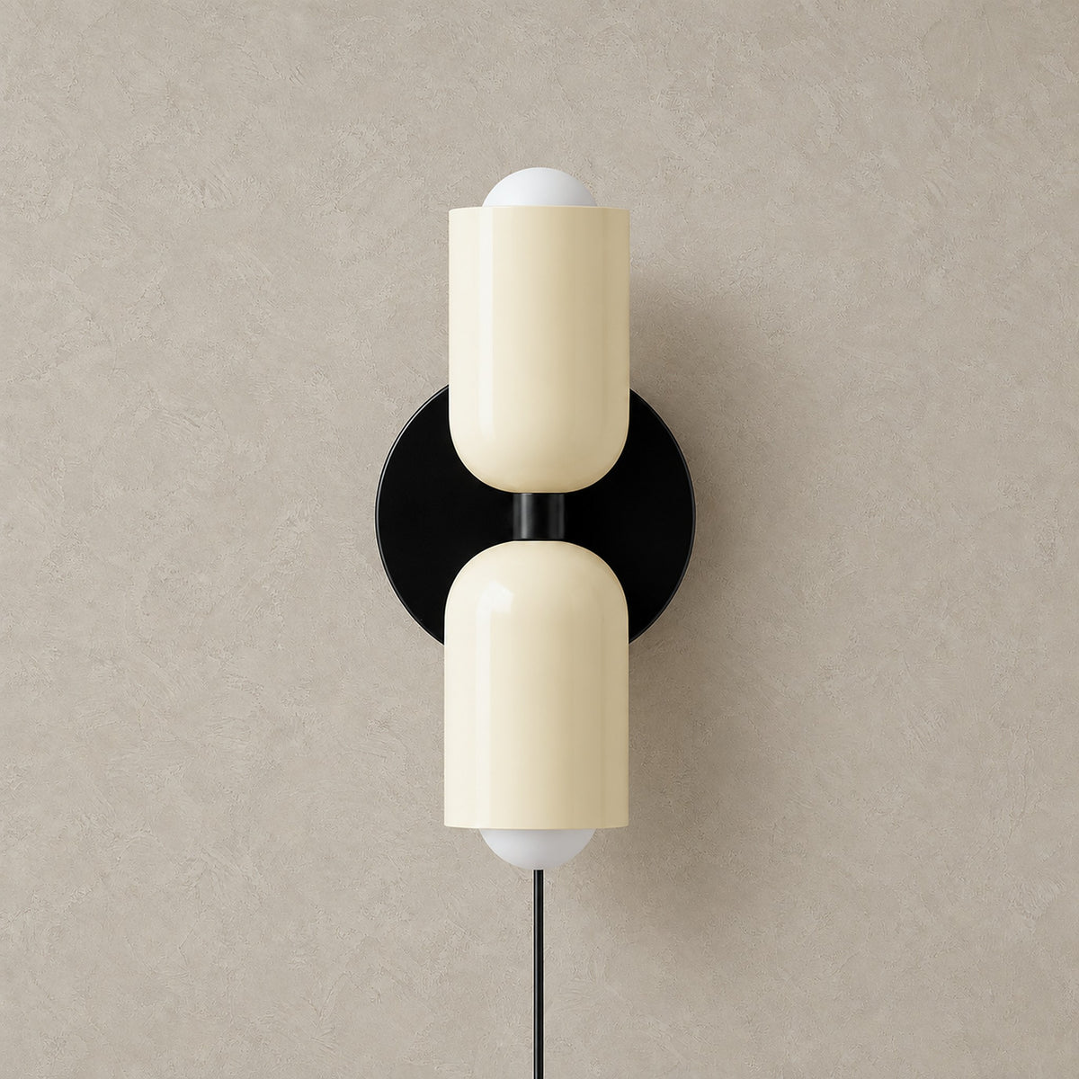 Talomi beige plug in wall sconce unlit in a front view showing the round backplate and upward and downward heads