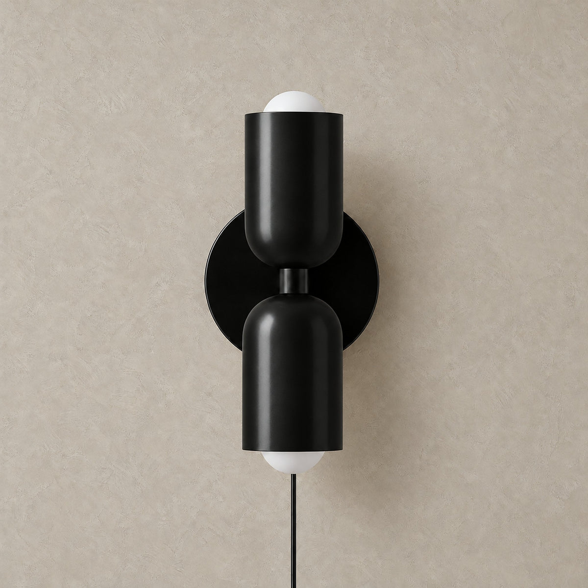 Talomi black plug in wall light unlit on a plain backdrop showing its single color finish #color_black