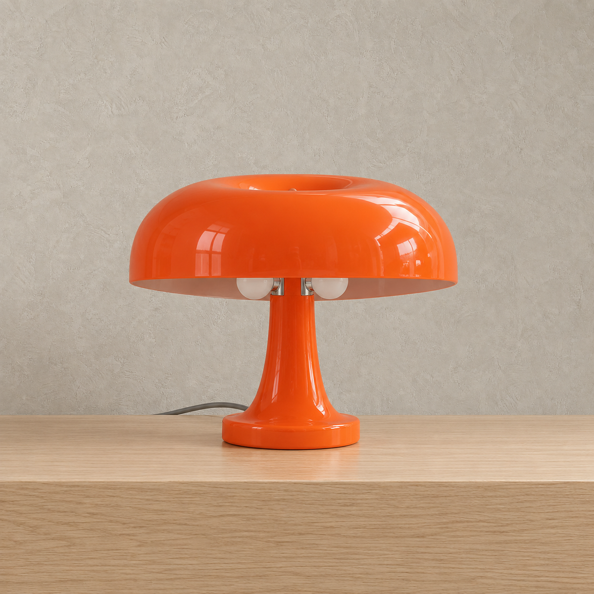 Tamolise mushroom table lamp in glossy orange, unlit against a warm greige plaster wall