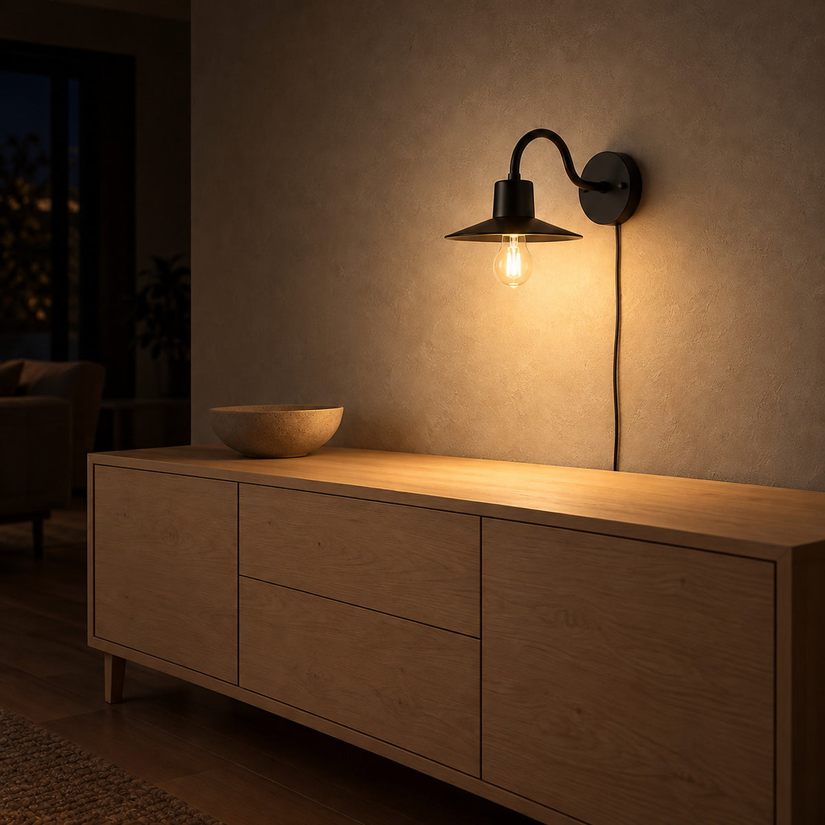 Tarelio black wall lamp with its vintage bulb glowing above a sideboard in a living room at night