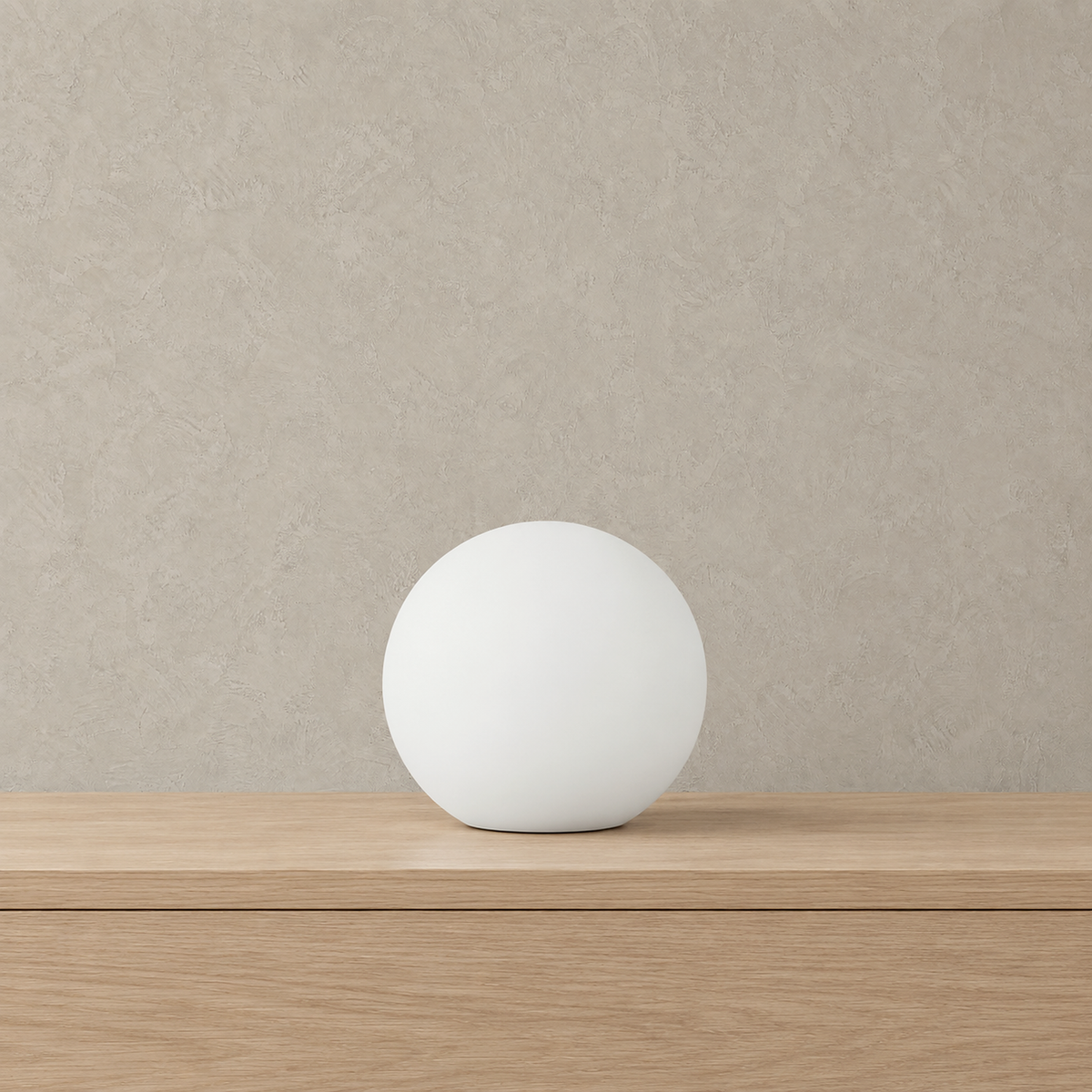 Tarmela rechargeable globe lamp in white, unlit on a pale tabletop showing the round ball shape