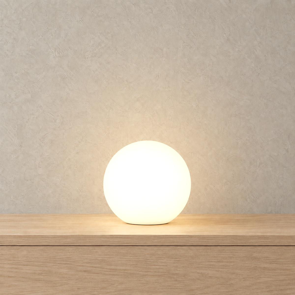 Tarmela white cordless table lamp lit in soft pink on a plain tabletop