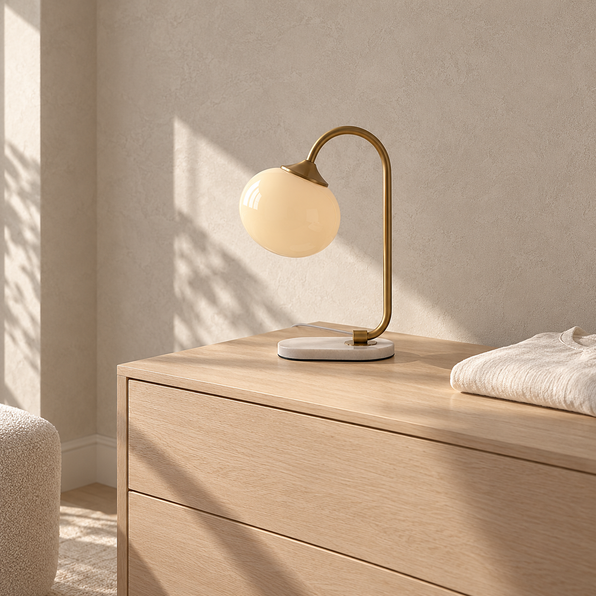 Taselvo gold and beige table lamp, unlit, on a sunlit dresser in a dressing room