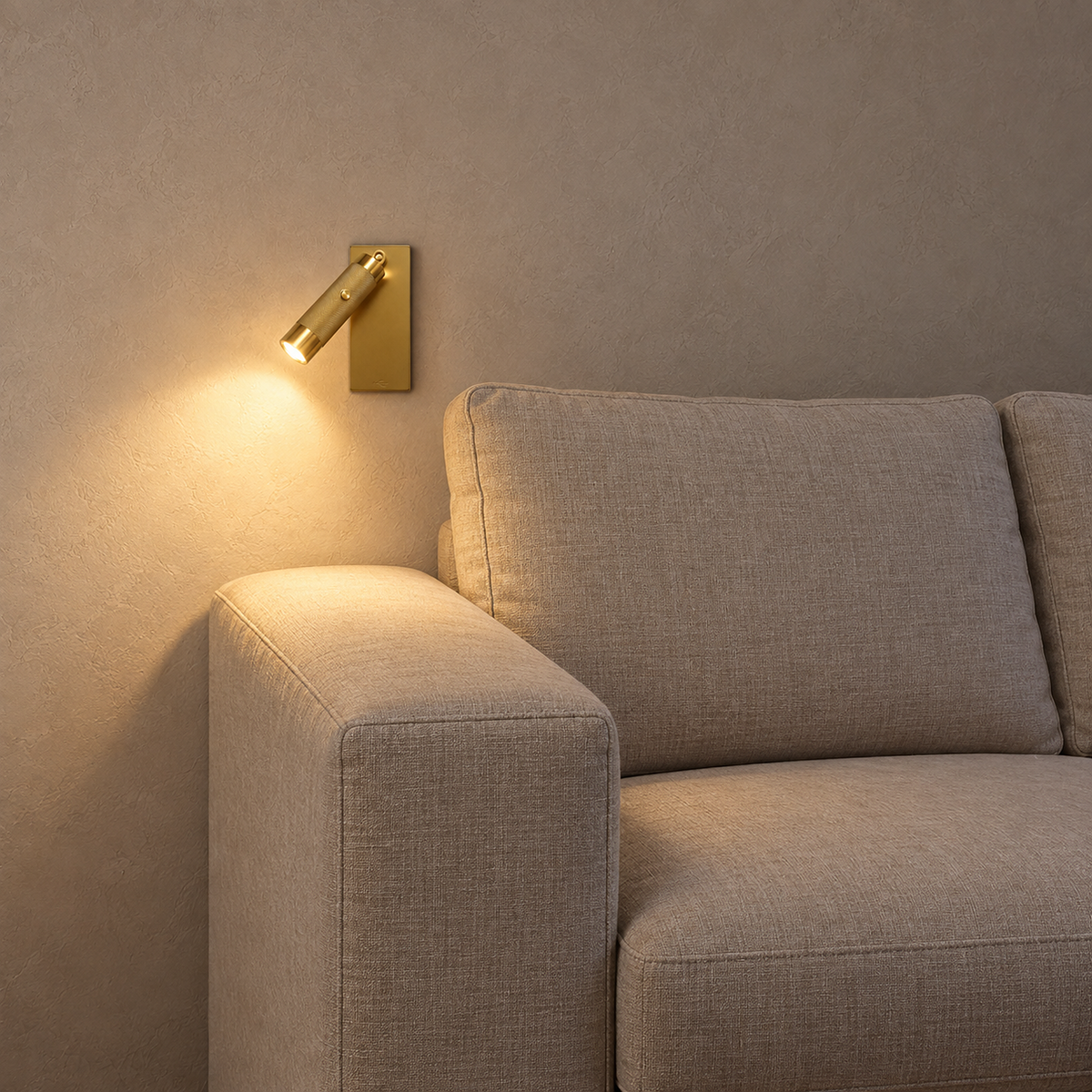 Tavelo gold bedside lamp lit beside a sofa with its round push switch within reach
