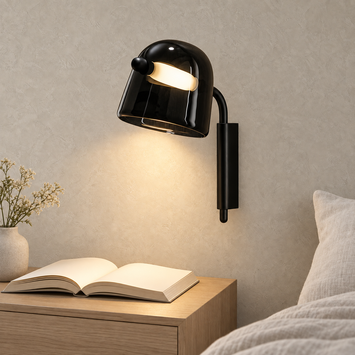 Tavessi black LED wall sconce lighting an open book in a sunlit guest bedroom