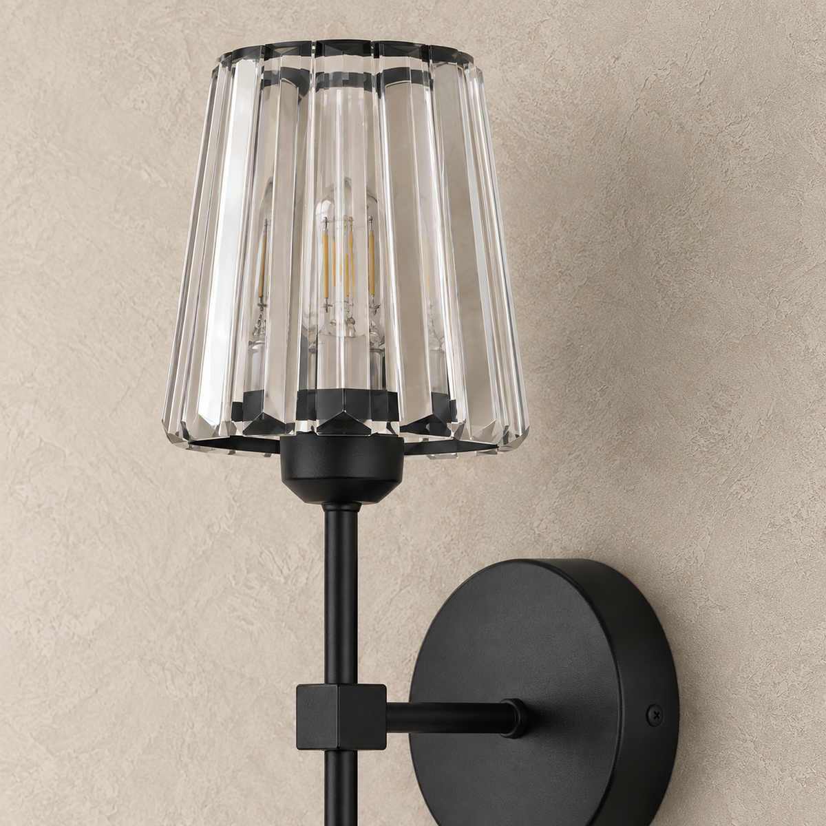 Tavirelo black LED wall sconce with unlit crystal facets seen close up in a dining room