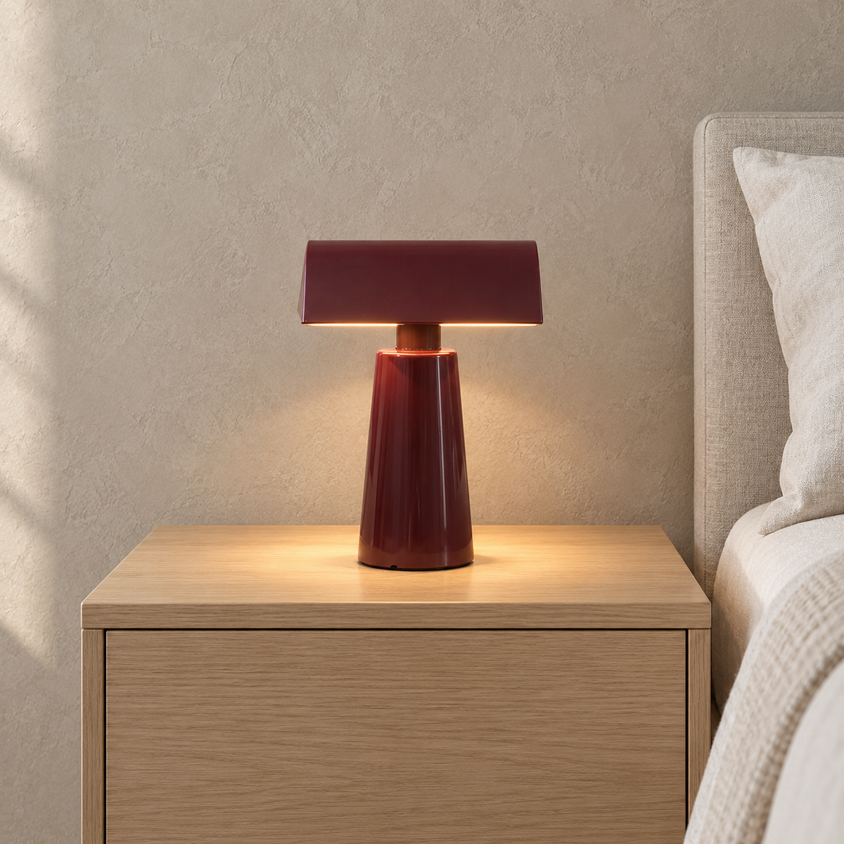 Ternilo red bedside lamp casting warm light onto a nightstand in a bright bedroom by day