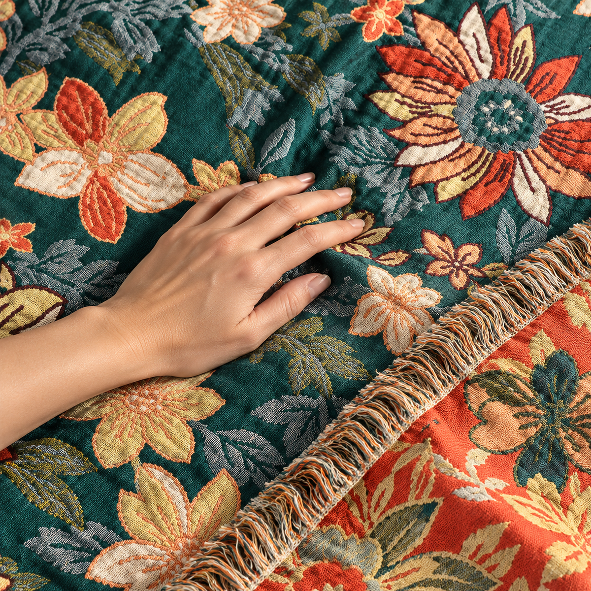 Tevarlo teal and orange soft throw blanket being smoothed flat by an adult hand