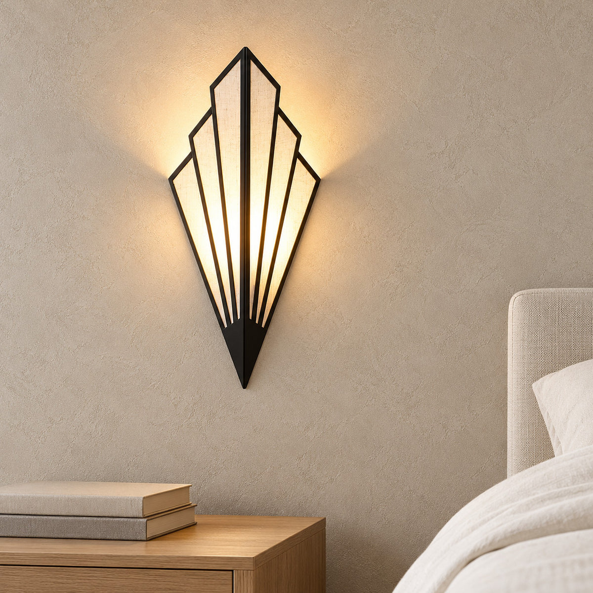 Ticorena black bedside wall light glowing above a clear nightstand in a guest bedroom