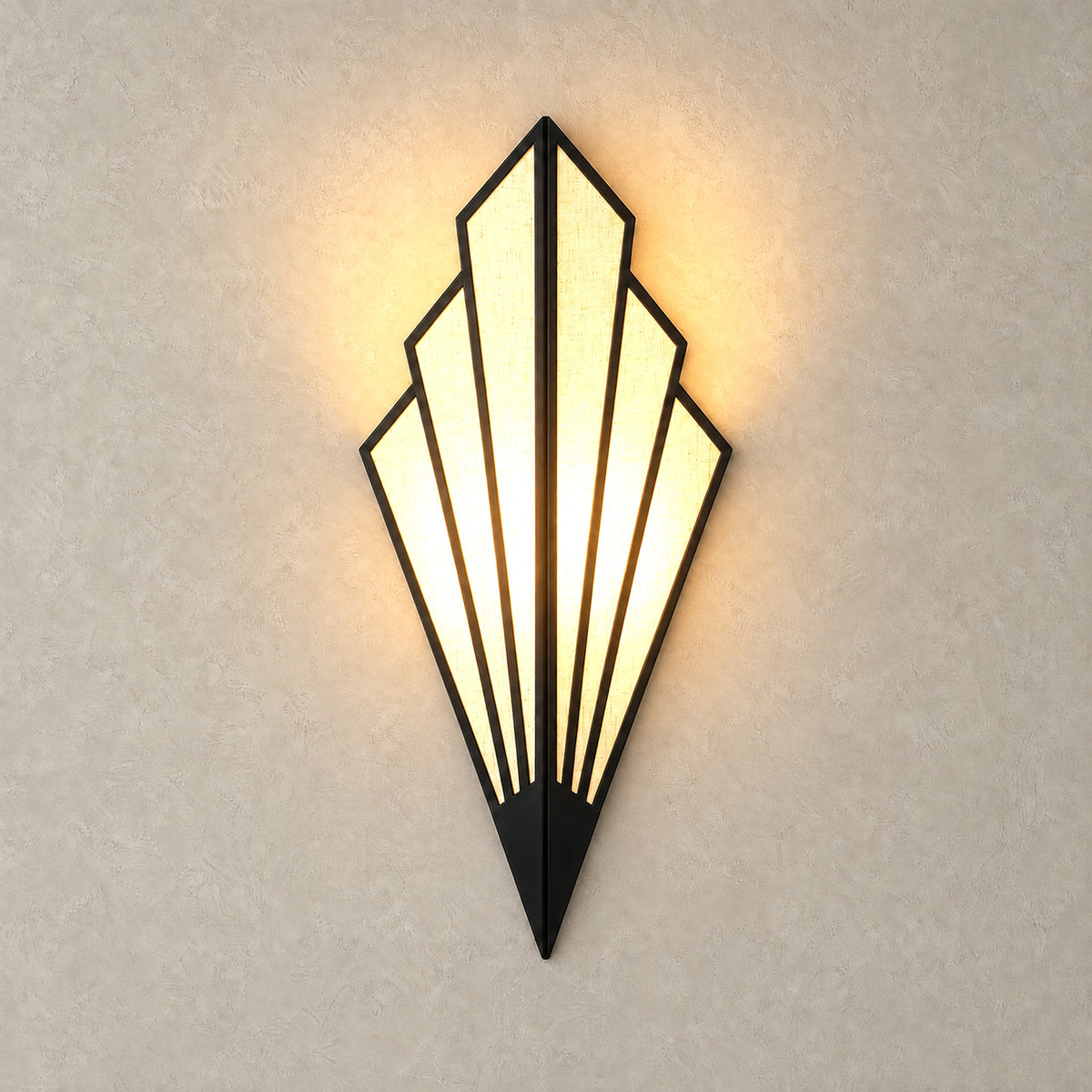 Ticorena black wall sconce lit, with light shining through its pale textured panels