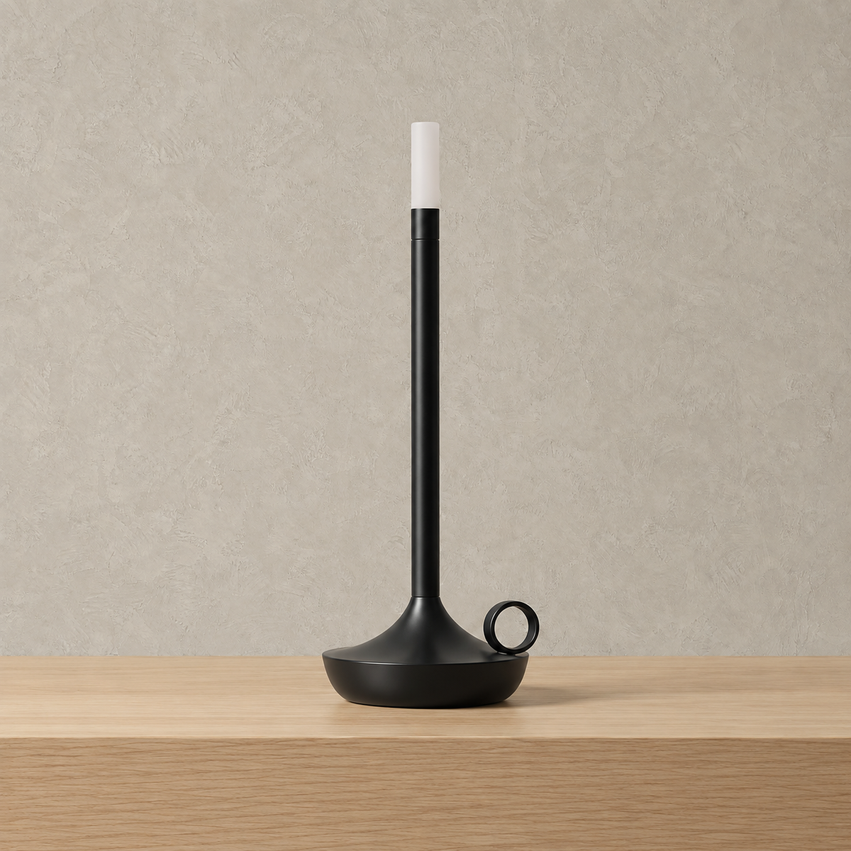 Tilmaro black rechargeable table lamp, a slim candle shaped light standing unlit on a plain tabletop