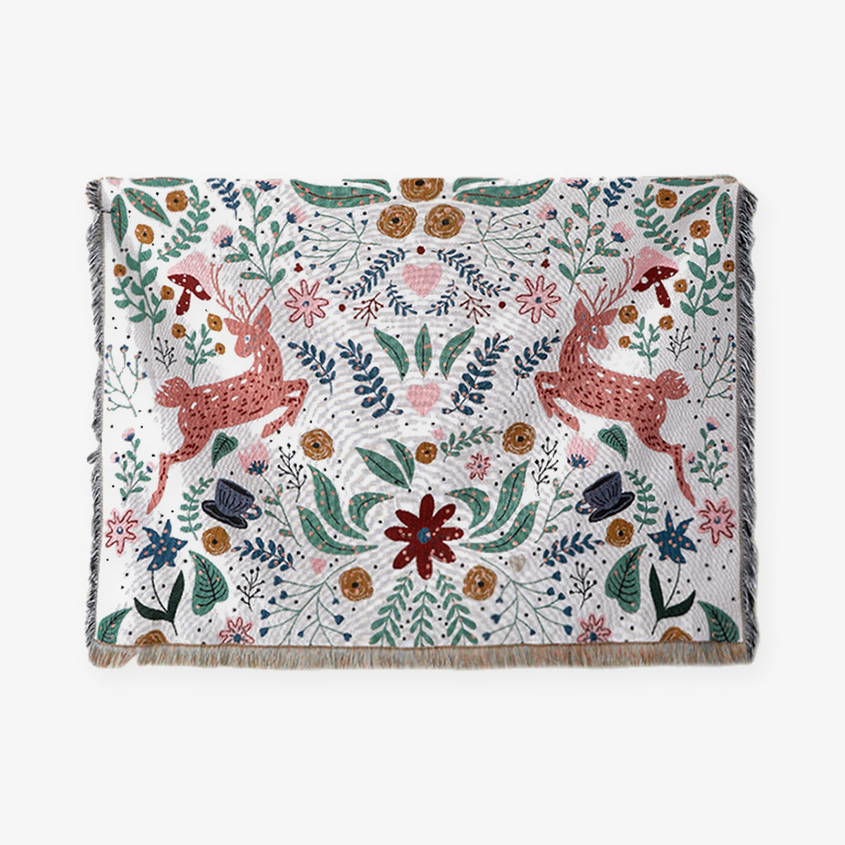 Tilmena tapestry throw blanket laid flat, showing pink deer, colorful florals and fringed edges on a light background.