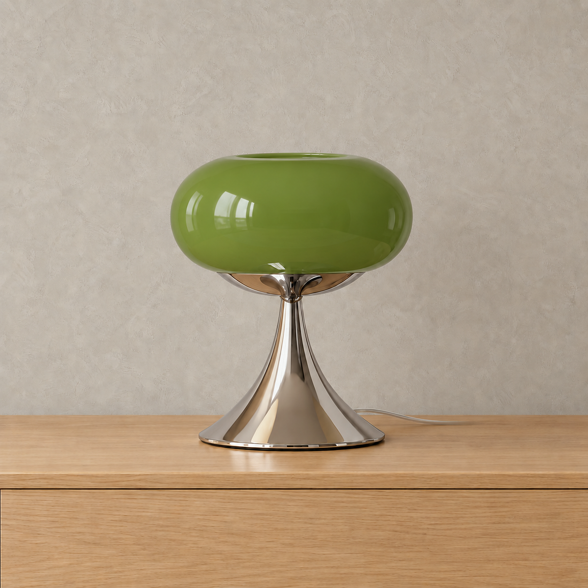 Tilvara stained glass table lamp in green, unlit on a plain backdrop with its metal base #color_green